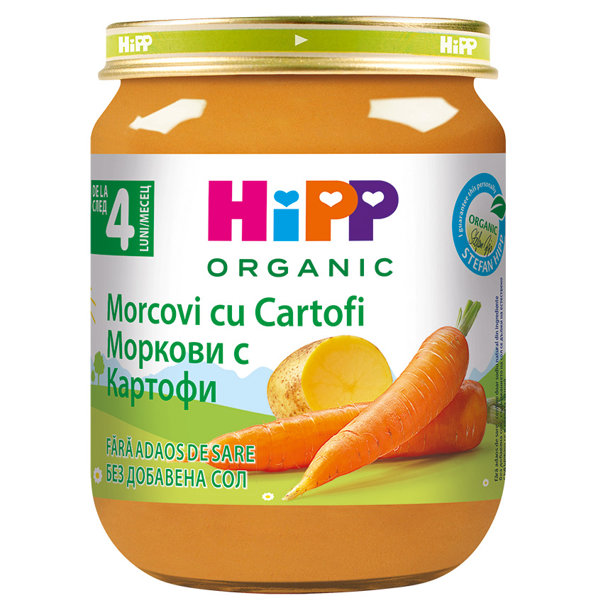Стъклен буркан с етикет, на който е изписан продукт, наречен "Morcovi cu Cartofi", на два езика, с изображение на нарязани картофи и моркови, с надпис "Organic" на видно място.