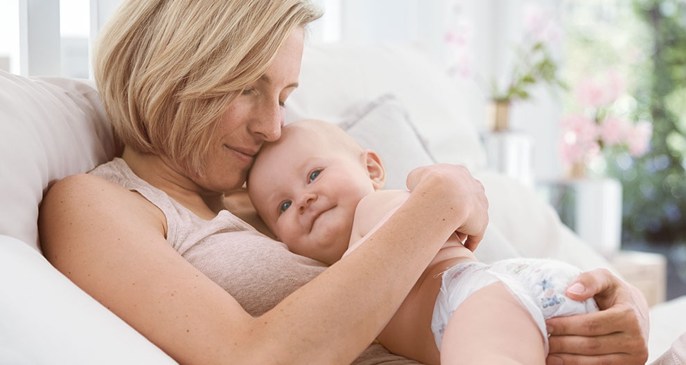 A woman is holding a baby.